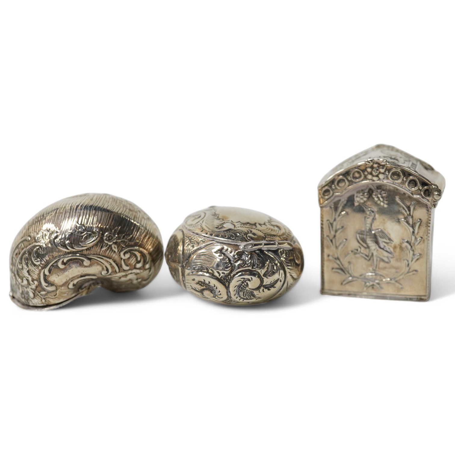 Three small silver boxes, including late Victorian modelled as a snail shell, import marks for London, 1898?, one modelled as a miniature cabinet, makers mark only and a late Victorian circular pill box. Condition - fair